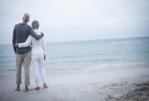 A man sitting on a deck chair looking at a swimming pool