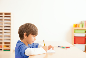 A boy writing with a pencil and paper