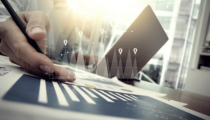 business documents on office table with smart phone and digital tablet and graph financial with social network diagram and man working in the background