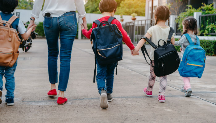 a group of young school children holding hands