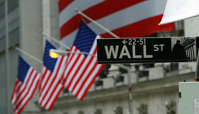 Wall Street street sign with US flags in the background