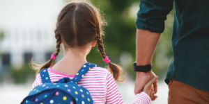 school girl holding fathers hand