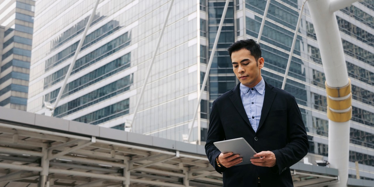 business man on tablet in city