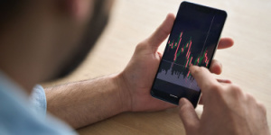 hand on mobile phone viewing investment markets information