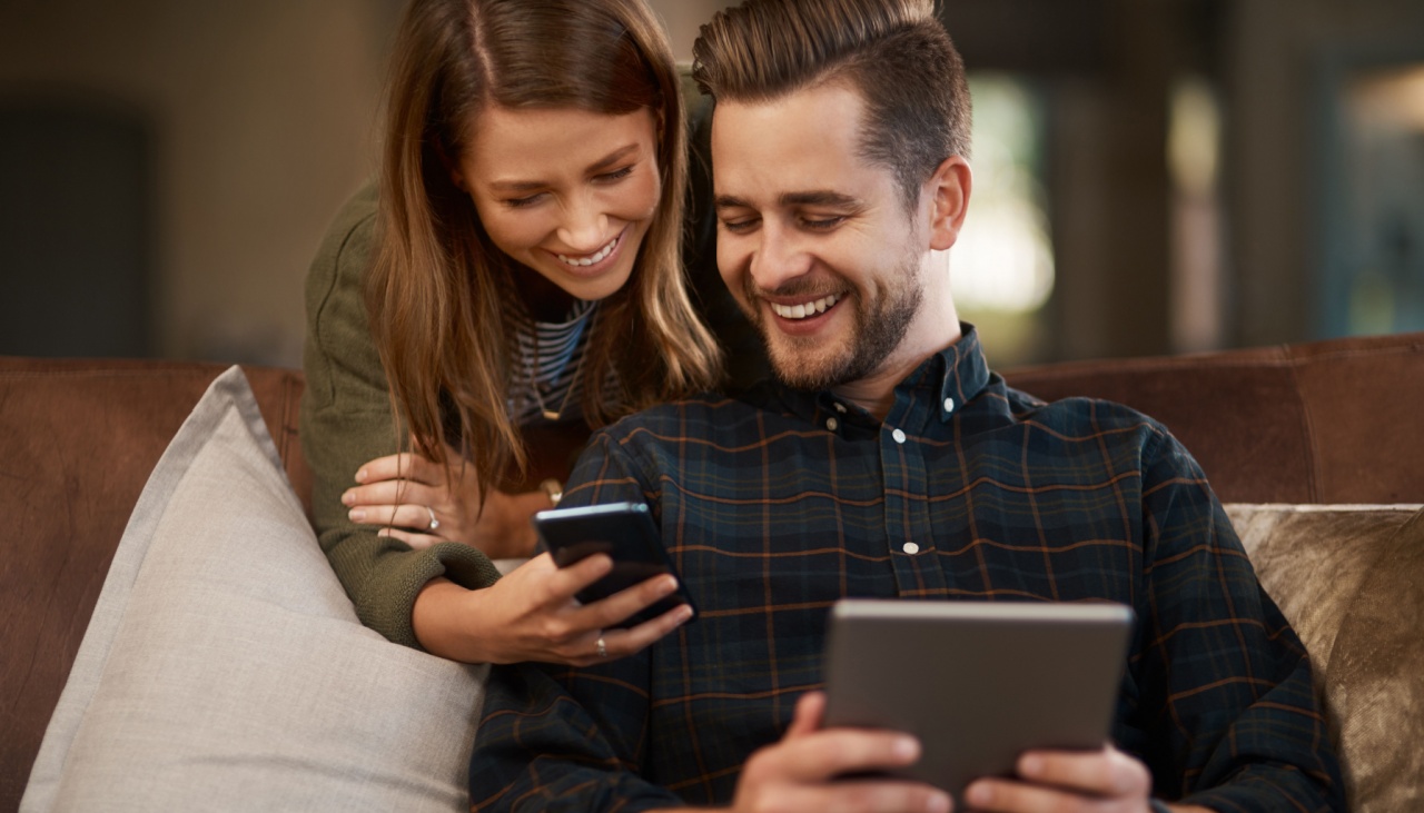 Couple at home on laptop and phone