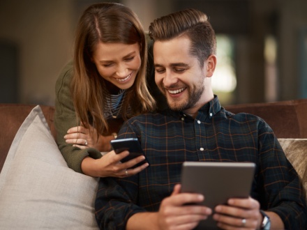 couple at home on laptop and phone
