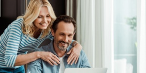 happy couple at home on laptop