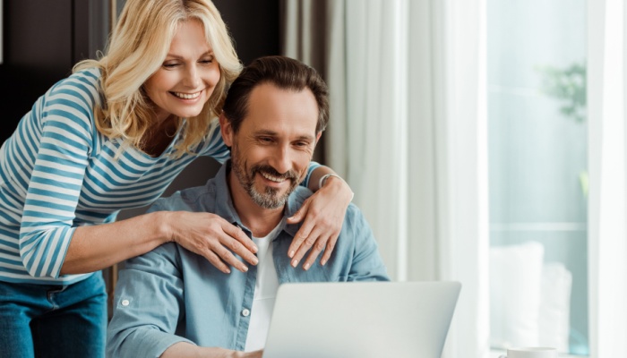 happy couple at home on laptop