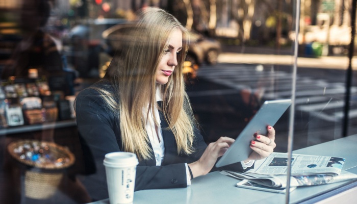 woman reading newspaper in coffee shop