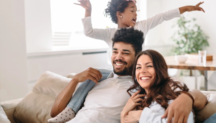 happy parents at home playing with child