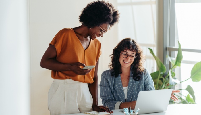two woman in office looking at laptop