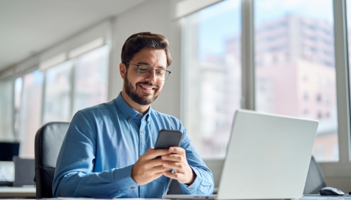 Smiling man on phone at office desk
