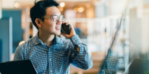 man on phone with laptop in hand
