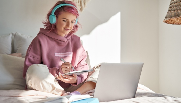 hipster teenager in bedroom studying
