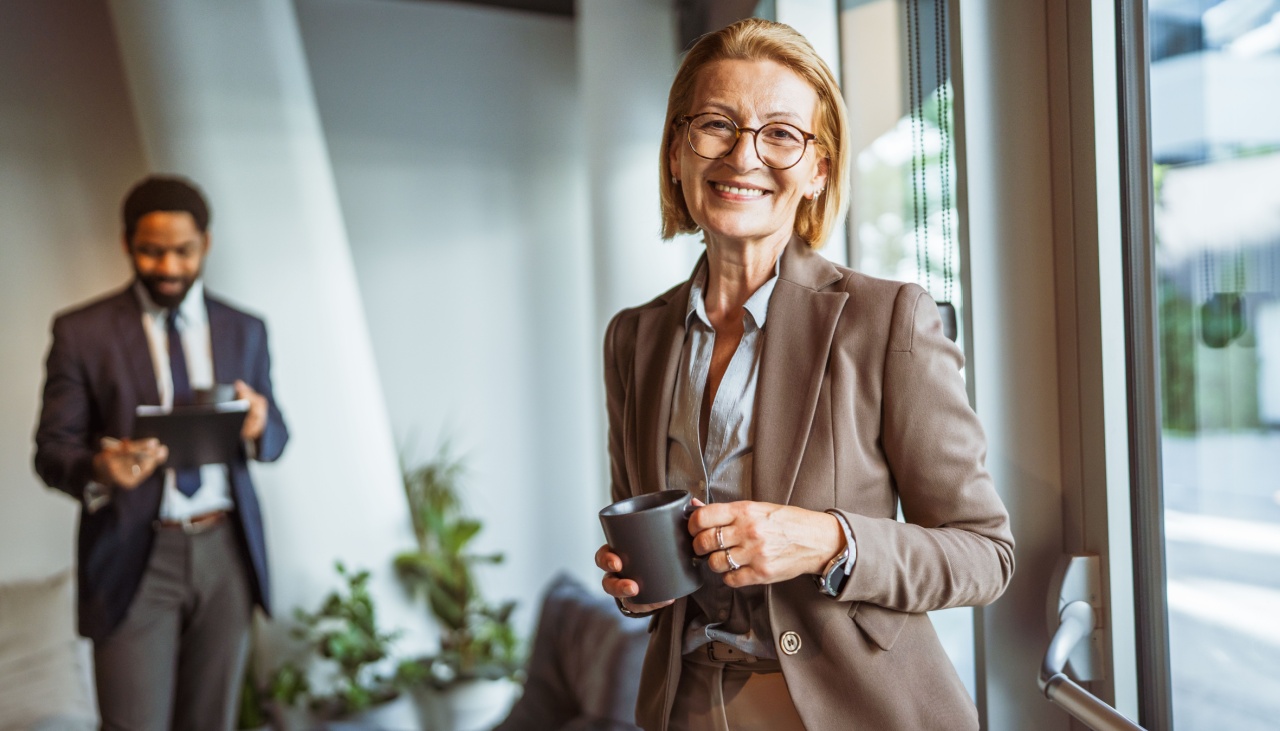 older female office worker with male colleague in the background