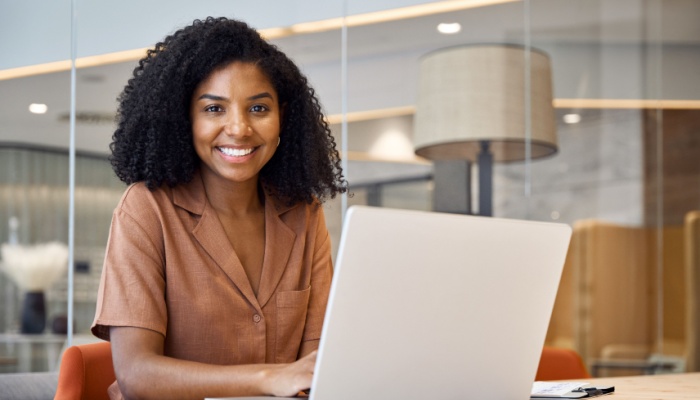 African woman at desk with laptop