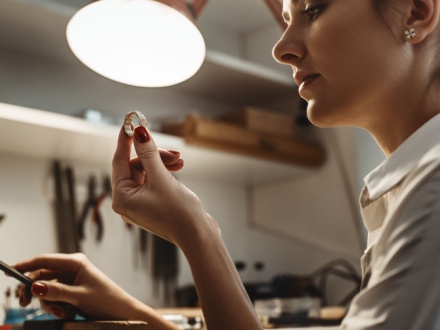 young female jeweler inspecting a ring
