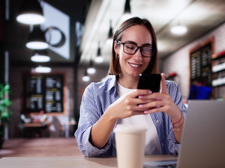 student in coffee shop on phone