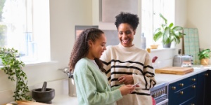 Mother and daughter in kitchen chatting
