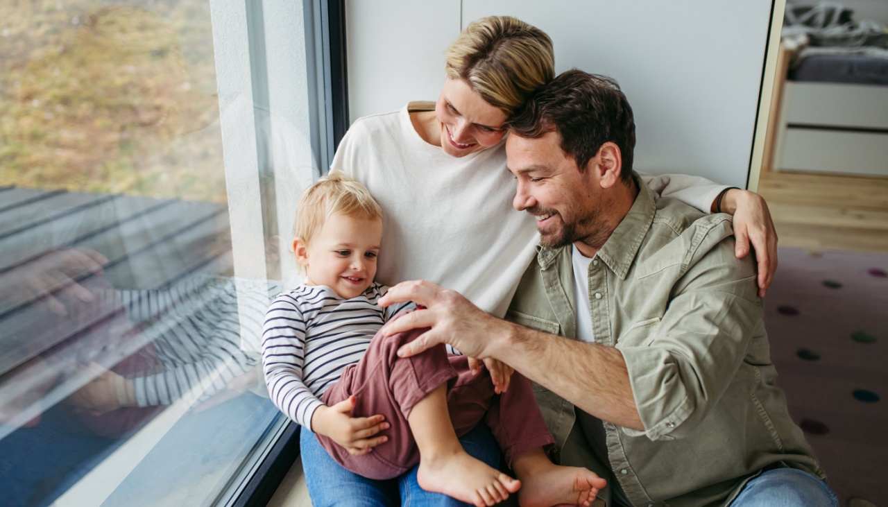 young family at home sitting by the window
