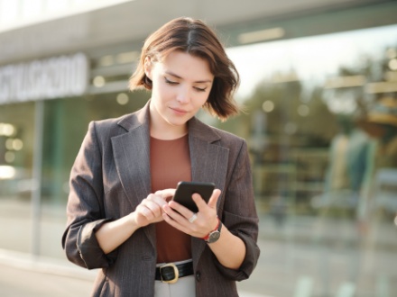 young business woman typing on her phone