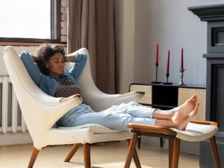 African woman at home relaxing in chair
