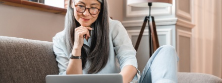 Woman with glasses looking at laptop