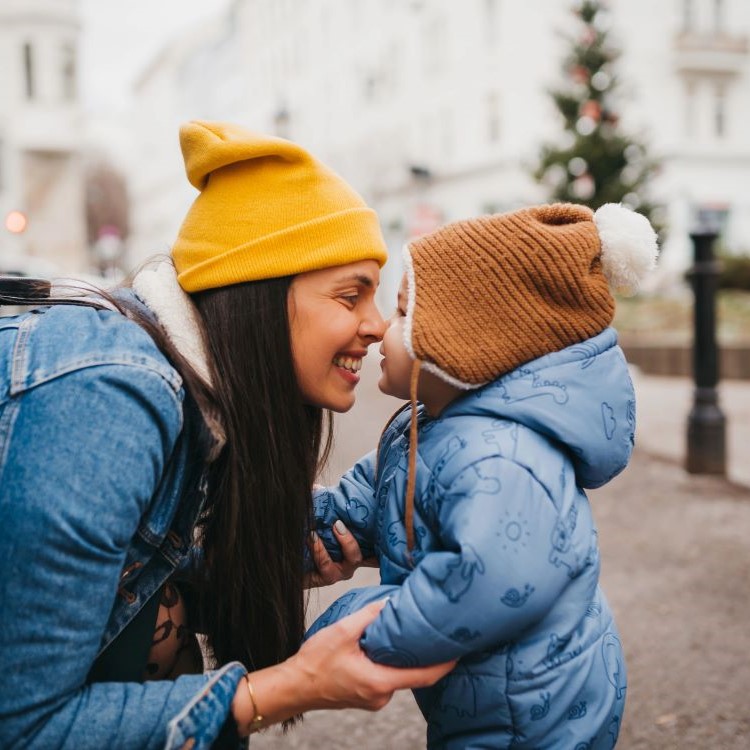 Woman holding hands with young child