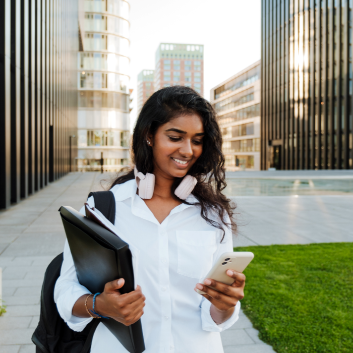 Woman with laptop on her phone outside offices