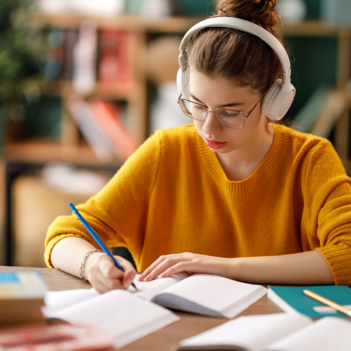 Young teenager studying school home work at a desk